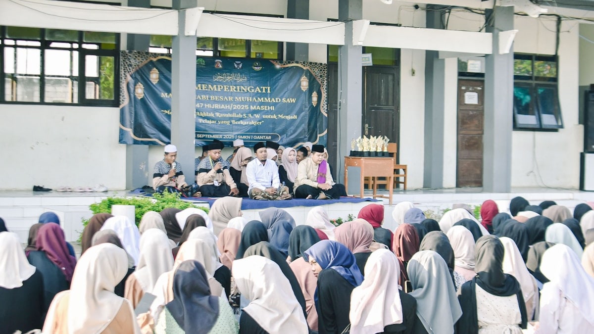 People gathered for an outdoor event with speakers on a stage.