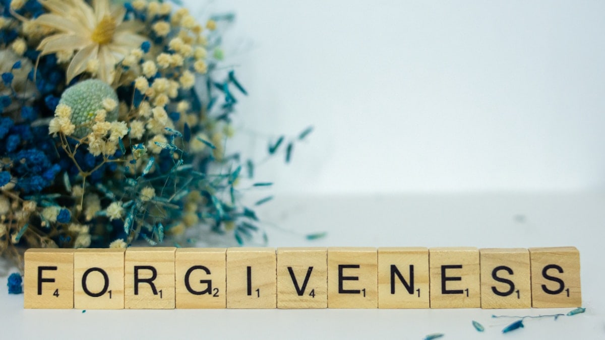 a scrabble type block spelling out the word forgiveness